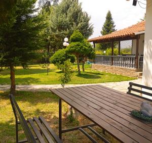 a wooden picnic table and two chairs in a park at Oasis Cottage in Krepeni +13 photos