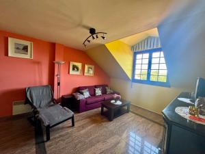 a living room with a purple couch and a window at Apartamento Tere in Llanes