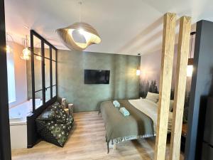 a bedroom with a bed and a chandelier at Craft Home - Le menuisier - Balneo - Parking privé in Saint-Étienne