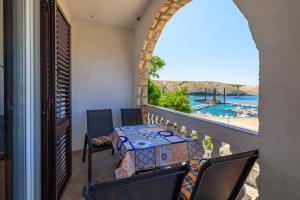 a balcony with a table and chairs and a view of the water at Apartments Albina in Lopar