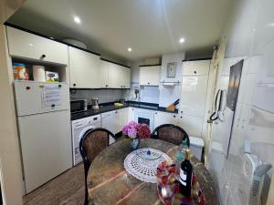 a kitchen with a table and chairs and a kitchen with white cabinets at Apartamento Tere in Llanes +14 photos