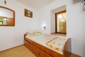 Un dormitorio con una cama y un espejo y una ventana. en Apartments Jug, en Lopar