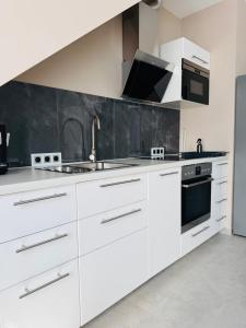 a white kitchen with white cabinets and a sink at Whitewill by Gerda in Groß Bartensleben +28 photos
