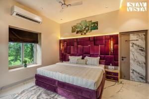 Un dormitorio con una cama grande con cabecero morado. en StayVista at Casa Tino with Bonfire, Lawn, en Karjat 26 fotos más