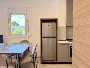 a kitchen with a refrigerator and a table with chairs at Vlora forest Apartments in Vlorë