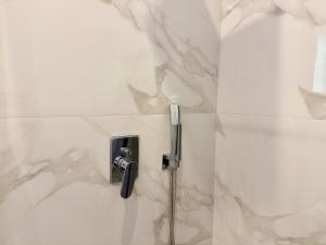 a shower in a bathroom with a shower facet at Vlora forest Apartments in Vlorë +49 photos