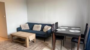 Una sala de estar con un sofá azul y una mesa. en Piaskowa Stay by LibertaRent, en Wałbrzych