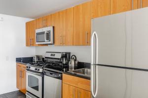 纽约Blueground Long Island City pool nr Gantry Plaza NYC-1844的厨房配有不锈钢冰箱和木制橱柜