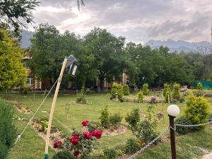a garden with flowers and a pole in the grass at Lidder view The best River side Resort in Pahalgam in Pahalgām