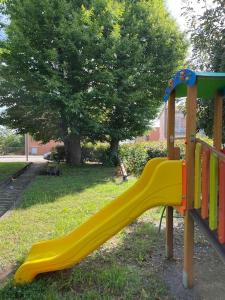 a playground with a yellow slide in a park at Wanderlust per chi ama la natura in Laino Castello