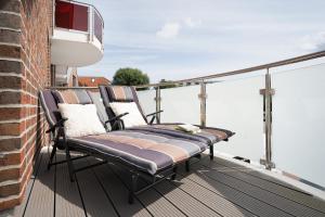 a couple of chairs sitting on a balcony at Blankwasserweg 57 Wohnung 5 in Grömitz