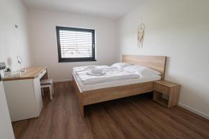 Un dormitorio con una cama y un escritorio y una ventana. en Sunset Villa Mara, en Liptovský Trnovec