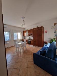 Una sala de estar con un sofá azul y una mesa. en La Casa di Taty, en Campagnano di Roma