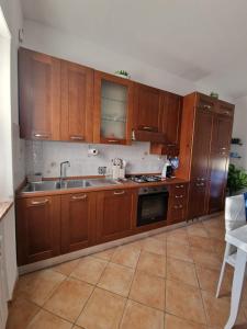 a kitchen with wooden cabinets and a sink at La Casa di Taty in Campagnano di Roma +12 photos
