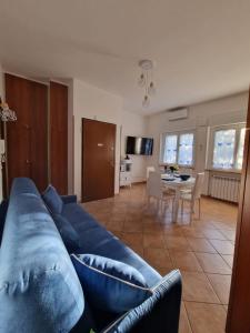 Una sala de estar con un sofá azul y una mesa. en La Casa di Taty, en Campagnano di Roma