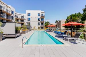 ein Swimmingpool mit Stühlen und Sonnenschirmen auf einem Gebäude in der Unterkunft Blueground Pleasant Hill balcony nr Park SFO-1906 in San Francisco
