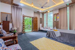 a living room with a large bed and windows at Ekayana Resorts and Agri Tourism, Mulshi in Pune
