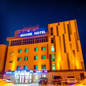 乌兰巴托Michid 1 Hotel的一家晚上停在酒店前面的汽车酒店