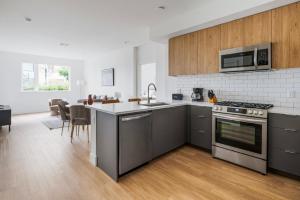 Blueground Ingold - Milldale pool nr Bayfront Park SFO-1897 في سان فرانسيسكو: مطبخ مع أجهزة ستانلس ستيل ودواليب خشبية