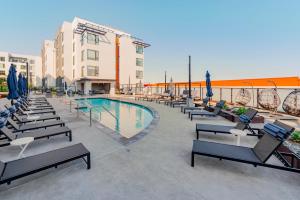 Blueground Ingold - Milldale pool nr Bayfront Park SFO-1897 في سان فرانسيسكو: فناء الفندق مع كراسي ومسبح