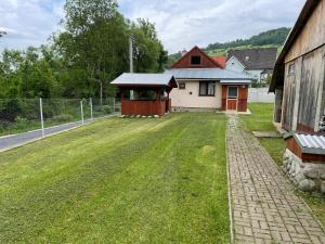 a large yard with a building and a fence at Chata Babulik in Veľká Lesná