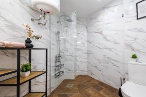 a bathroom with white marble walls and a shower at Estudio barrio Patraix - cerca del Centro in Valencia +29 photos