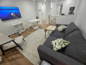 ポンタ・デルガダにあるApartamento Sonho Brisaのソファとテーブルのあるリビングルーム