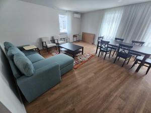 a living room with a couch and a table and chairs at Apartamento Sonho Mar in Ponta Delgada