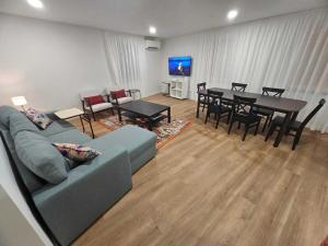 a living room with a couch and a table and chairs at Apartamento Sonho Mar in Ponta Delgada