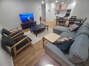 a living room with a blue couch and a tv at Apartamento Sonho Terra in Ponta Delgada