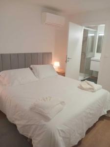 a white bed in a bedroom with a mirror at Apartamento Sonho Terra in Ponta Delgada