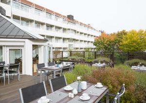 a patio with tables and chairs and a building at Living Hotel Nürnberg in Nürnberg