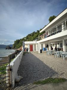 a building on the beach next to the ocean at Villa Ebarle Diving Resort in Mabini