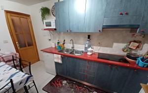 cocina con fregadero y encimera roja en Habitaciones Gioly, en Puerto del Rosario