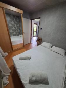 a bedroom with a large white bed and a mirror at Bunaglows Panoramic Beach Village in Balchik