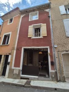 a red brick building with a window and a table at Maison Ventoux Vacances in Bédoin