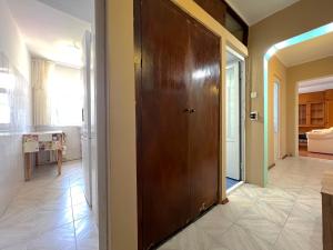 a hallway with a large wooden door in a house at Apartament 2 Camere - 150m plaja - Saturn Mangalia in Saturn +2 photos