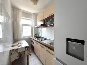 a small kitchen with a stove and a sink at Apartament 2 Camere - 150m plaja - Saturn Mangalia in Saturn