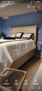 a large bed in a room with a sign on it at Sunshine Beautiful in Falmouth