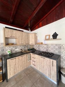 a kitchen with wooden cabinets and a black counter top at Casa Maxim Eforie Nord in Eforie Nord