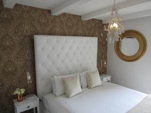 a bedroom with a white bed and a mirror at Orewa Beachcomber in Orewa