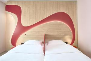 a bedroom with two beds and a wooden headboard at Prize by Radisson, Munich Airport in Hallbergmoos