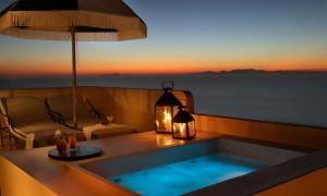 a jacuzzi tub with a view of the sunset at Terra Verde Oia by K&K in Oia