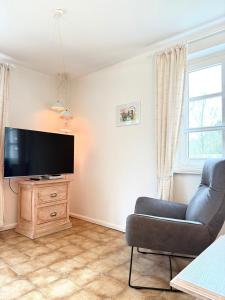 a living room with a couch and a flat screen tv at Haus Bornholm Whg 03 in Nieblum