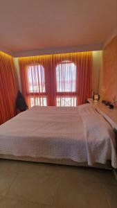 a bedroom with a large bed and two windows at Beachfront Apartment Oasis VIP Club in Sunny Beach