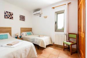 a bedroom with two beds and a window at Villa Caballero by Villa Plus in Punta Prima +26 photos