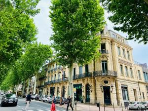 a building on a city street with people crossing the street at Appartement T2 Méditerranéen in Narbonne