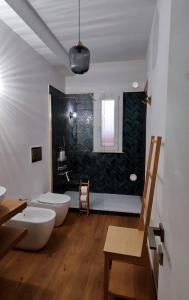 a bathroom with two white toilets and a green wall at Disìu Apartment con Jacuzzi in centro a Castellammare del Golfo in Scopello +22 photos