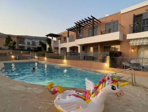a swimming pool with a unicorn in front of a building at Sunny Bliss in Peyia