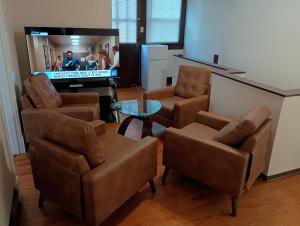 a living room with chairs and a flat screen tv at charming apartment at Lynchburg in Lynchburg